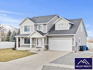 View of front of house with driveway, a porch, roof with shingles, and stone siding