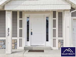 Property entrance featuring a porch and stone siding