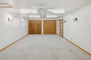 Unfurnished room with ceiling fan and carpet