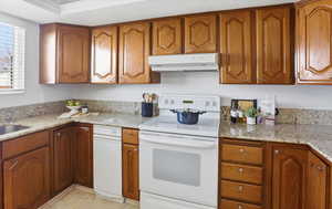 Kitchen with wood finish cabinets, white electric range, light stone countertops, and a textured ceiling