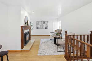 Living area featuring light wood-style floors and a glass covered fireplace