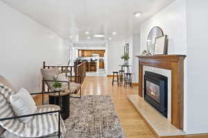 Living area with light wood-style flooring, a fireplace, and recessed lighting