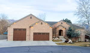 View of front of home with timeless  brick, driveway, and an attached oversized garage.