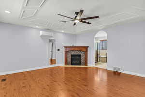 Unfurnished living room with ceiling fan, LVP flooring, a tile fireplace