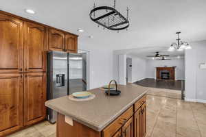 Kitchen featuring wood finish cabinetry, a kitchen island, stainless steel fridge with ice dispenser.