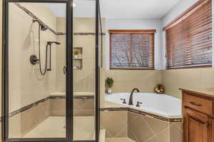 Full bath with vanity, a stall shower, and a bath