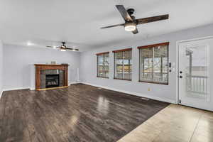 Unfurnished living room with light wood-style floors, ceiling fan, and a fireplace