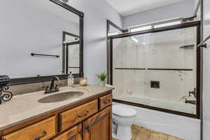 Guest Bathroom with vanity, shower / bath combination with glass door,