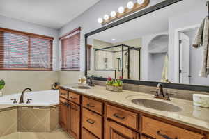 Full bathroom with double vanity, a shower, a garden tub,