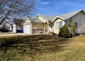 Ranch-style home with a garage, a front yard, and driveway