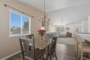 Dining room featuring dark wood-type flooring, plenty of natural light, ceiling fan, and vaulted ceiling