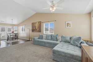 Living area featuring carpet floors, ceiling fan, and healthy amount of natural light
