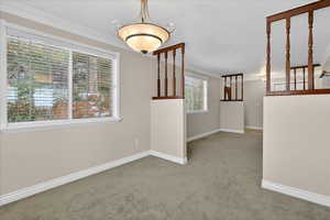 Unfurnished room featuring light carpet and crown molding