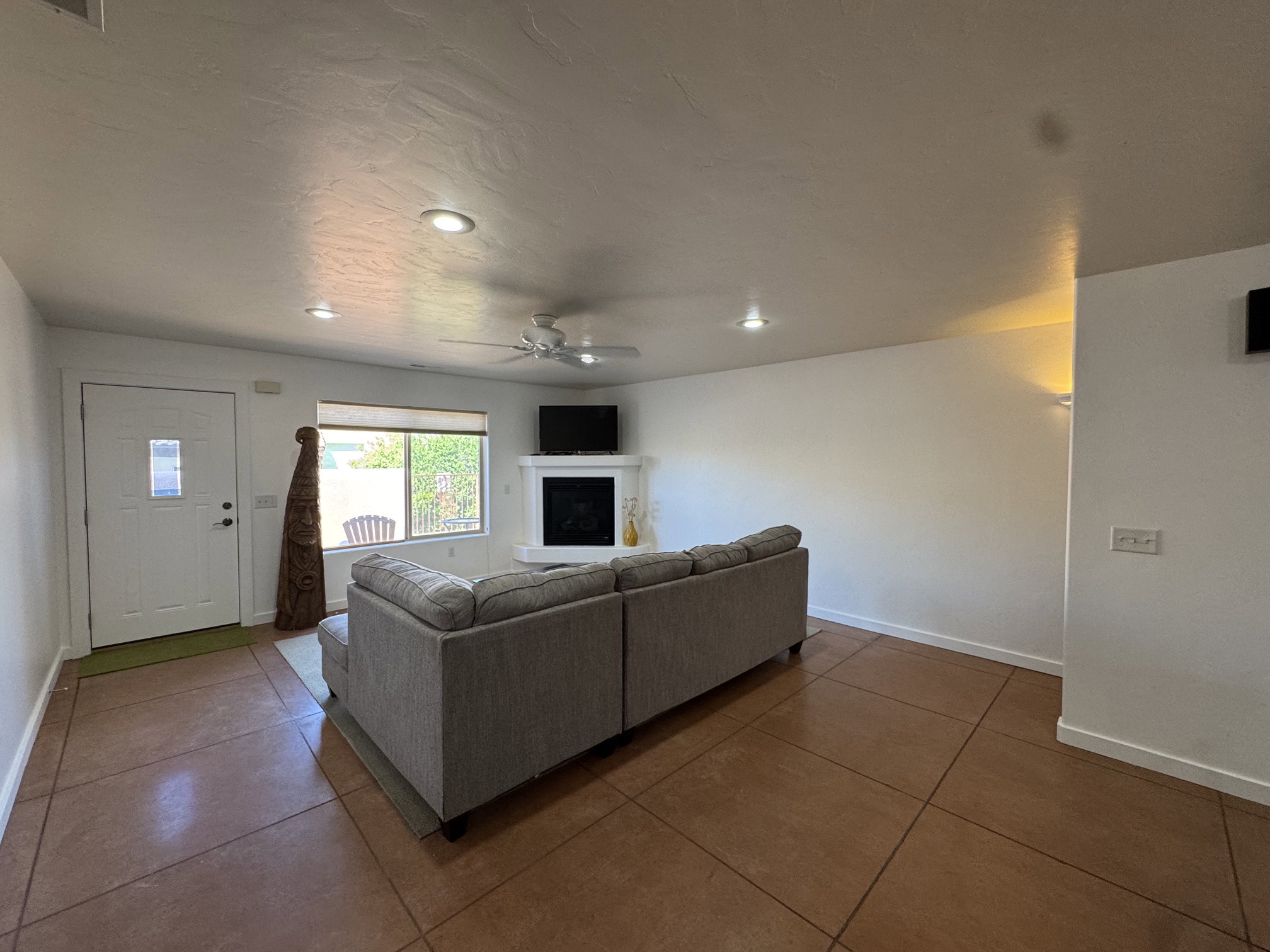 Open-concept living area featuring a corner fireplace, recessed lighting, and a ceiling fan