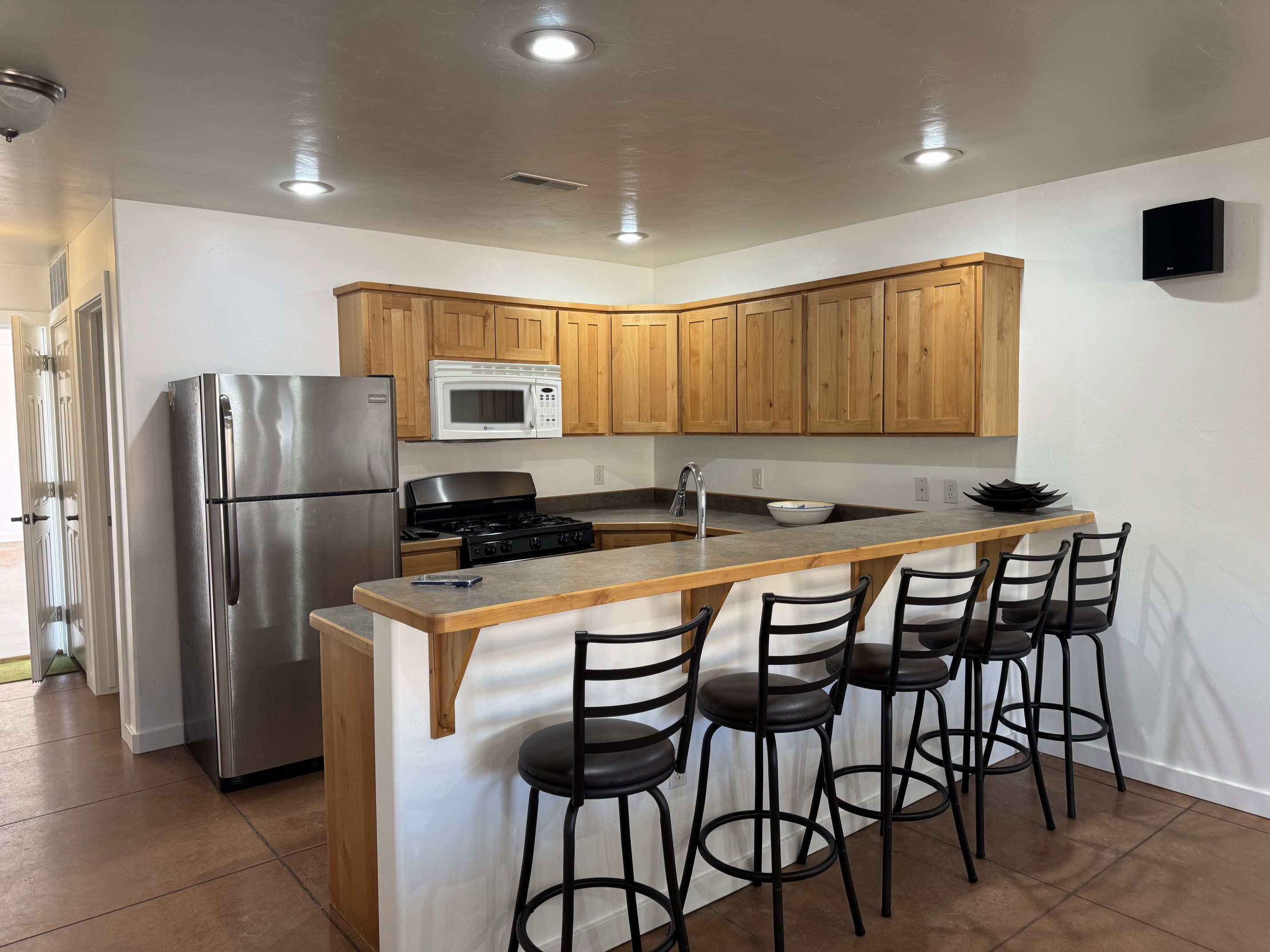 Kitchen featuring a stainless steel refrigerator, gas range, built-in microwave, and wood cabinetry