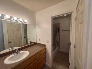 Bathroom featuring vanity, shower / bath combo with shower curtain, and light tile patterned floors