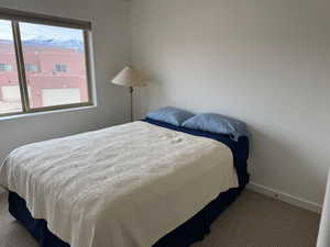 Carpeted bedroom with baseboards and a mountain view