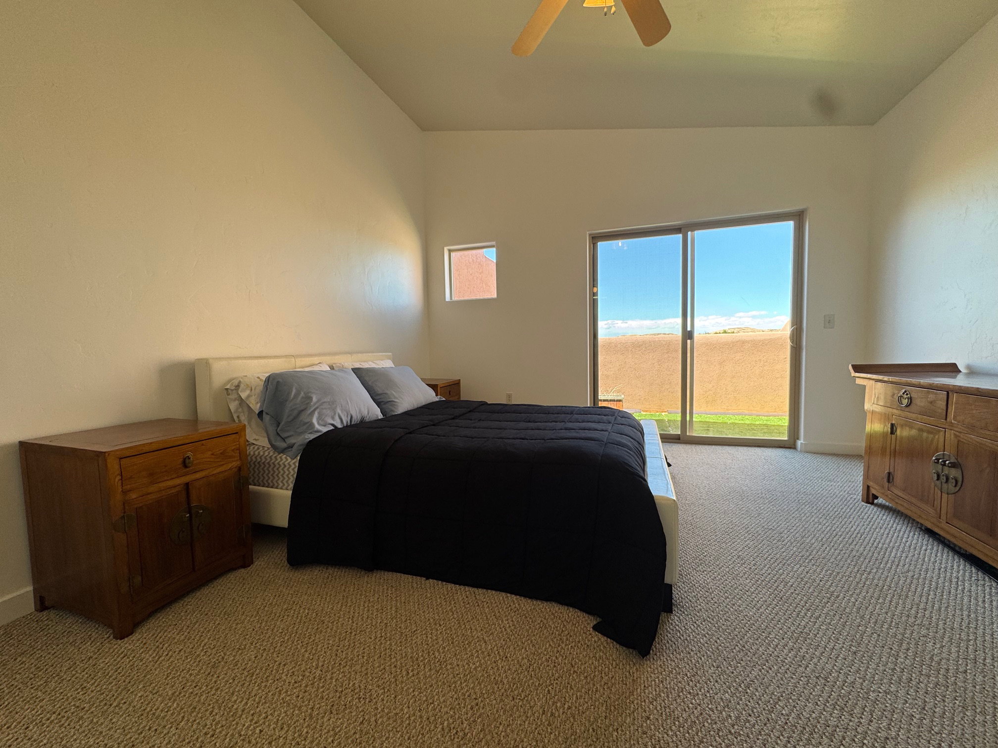 Bedroom featuring light carpet, vaulted ceiling, access to deck.  Spacious and room for any size bed.