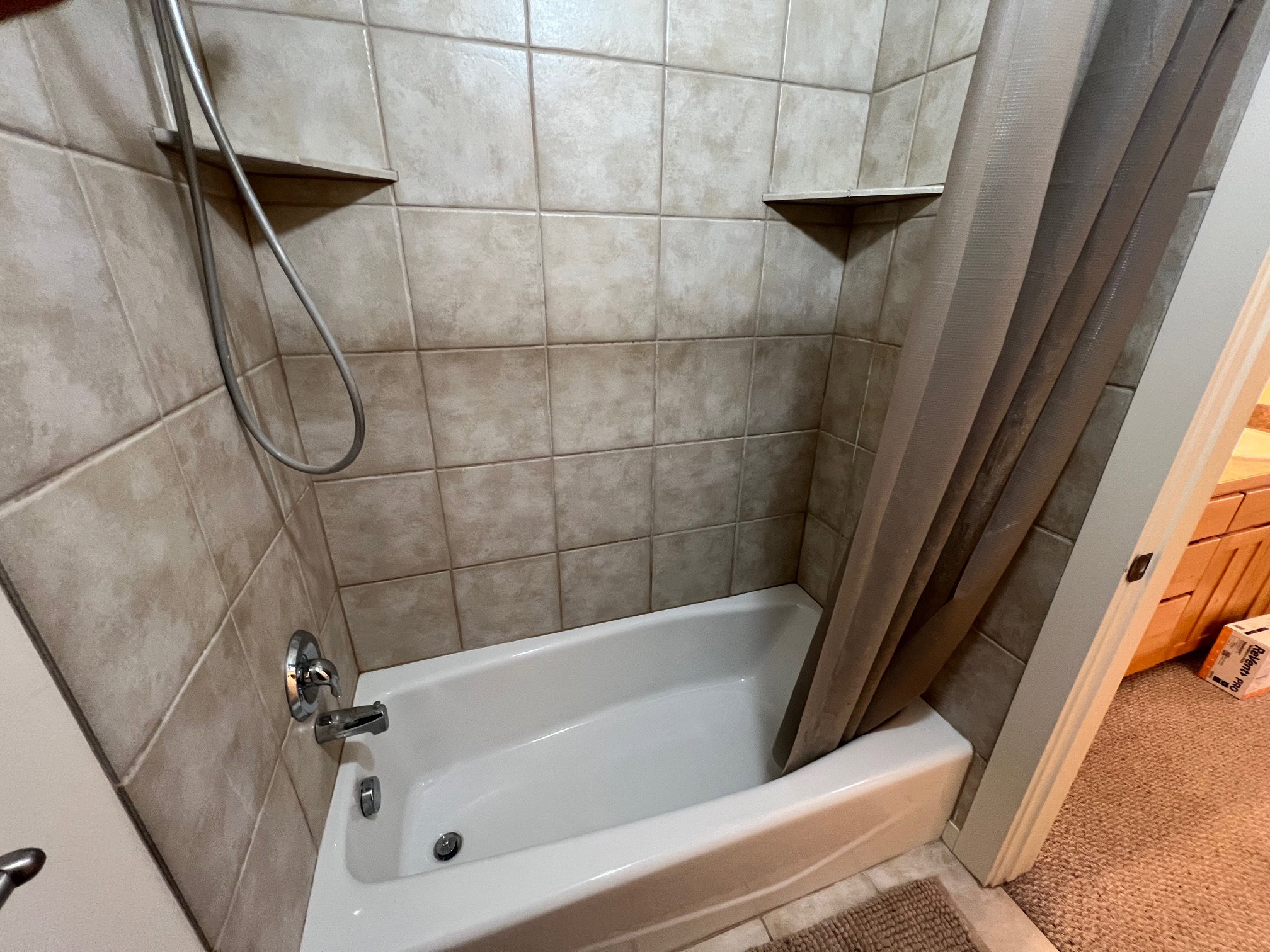 Bathroom with shower / bath combination with curtain and tile floors.