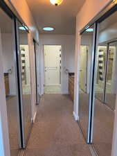 Corridor with light carpet and baseboards