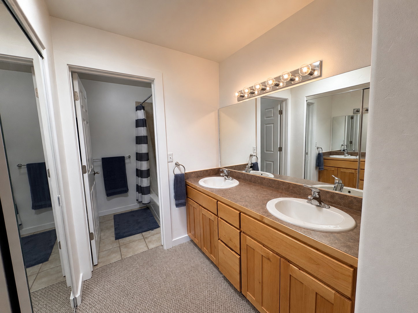 Double vanity with integrated sinks and wood-finish cabinetry