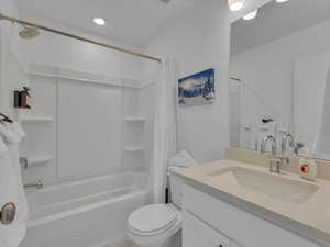 Full bathroom with vanity, shower / tub combo, and recessed lighting