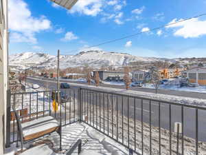 Snow covered back of property with a mountain view