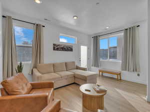 Living area with wood finished floors and recessed lighting