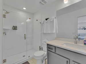 Ensuite bathroom featuring vanity, a stall shower, and light tile patterned flooring
