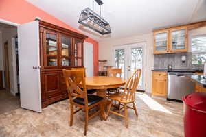 Dining space featuring french doors and vaulted ceiling