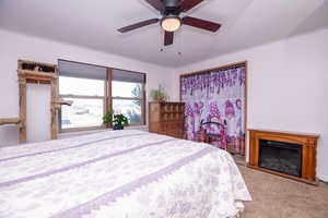 Bedroom featuring a textured ceiling, carpet, and ceiling fan