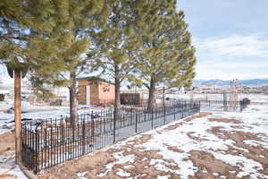 Yard layered in snow featuring a mountain view and an outdoor structure