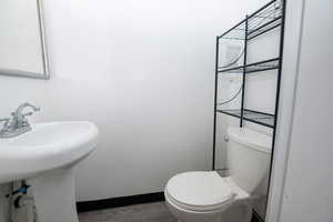 Bathroom with baseboards and dark wood-style flooring