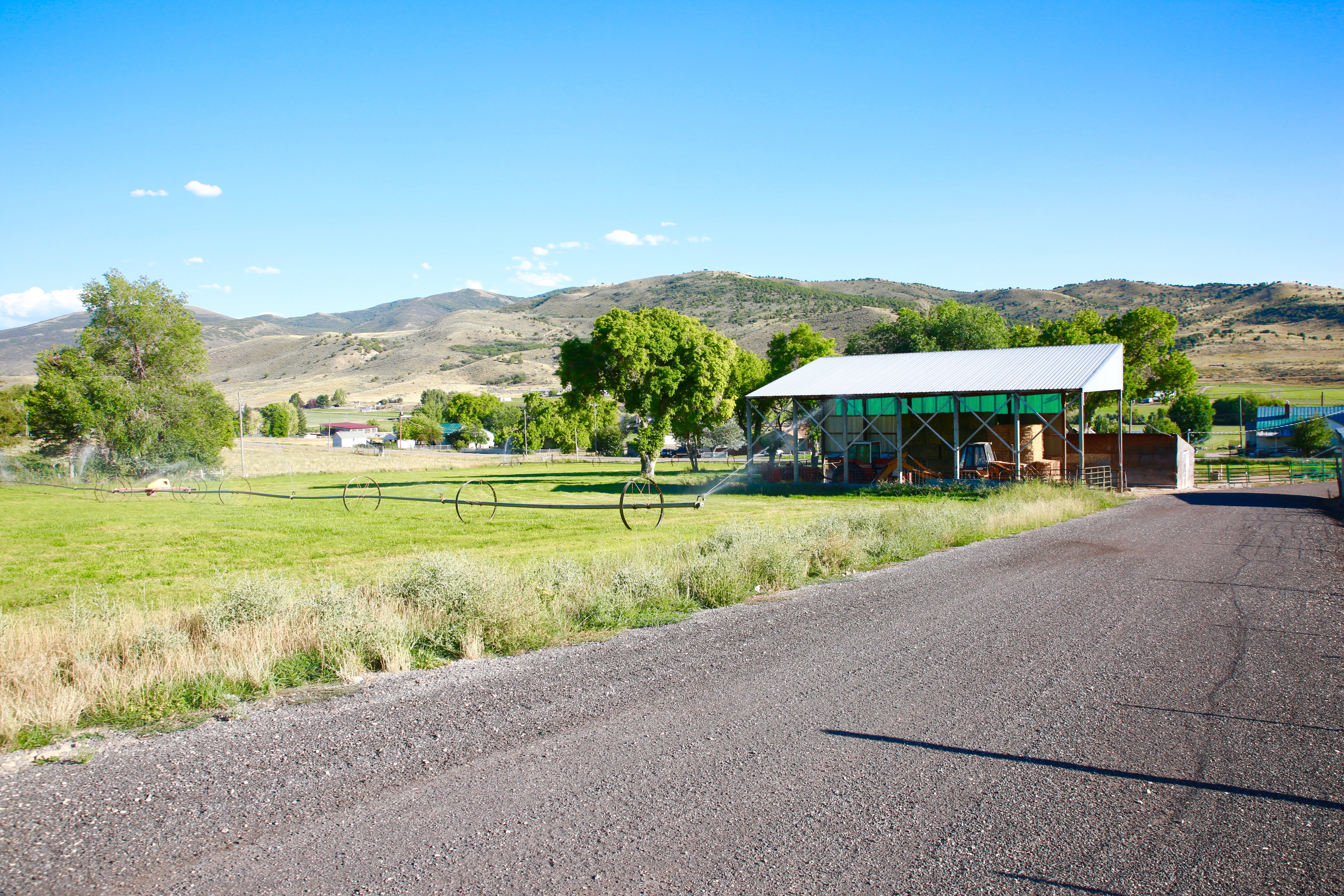 View of asphalt road featuring a mountain view and a view of rural / pastoral area