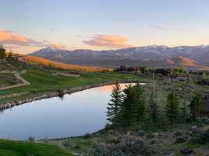 Water view with mountains and a golf course