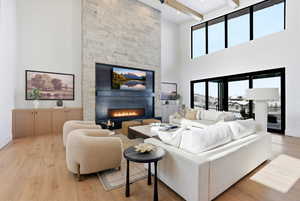 Living area with a large fireplace and light wood-type flooring