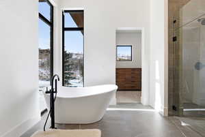 Bathroom with a freestanding bath, a stall shower, and tile patterned floors