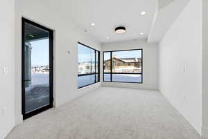Spare room featuring light colored carpet, recessed lighting, and a water view