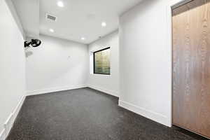 Spare room with dark carpet and recessed lighting