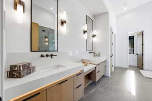 Bathroom with two vanities, a stall shower, and recessed lighting