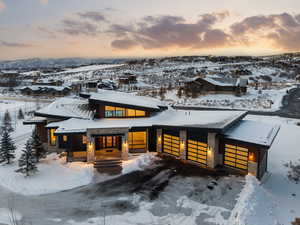 Modern home featuring stone siding, a garage, and driveway
