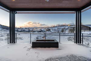 Snow covered patio with a mountain view
