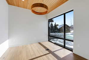 Unfurnished room with wooden ceiling and wood-type flooring