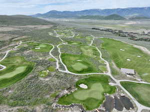 Drone / aerial view of a mountain backdrop and a golf course
