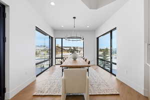 Dining area with light wood-style floors and hanging lights