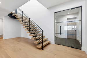 Staircase with wood finished floors and recessed lighting