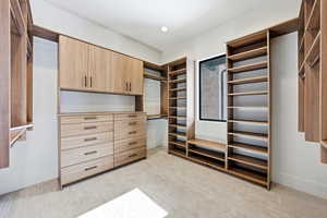 Walk in closet featuring light colored carpet