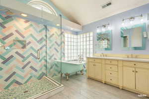 Principle bath with a shower stall, lofted ceiling, double vanity, a freestanding bath, and a textured wall