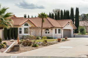 Mediterranean / spanish-style home with stucco siding, concrete driveway, an attached garage, and a tiled roof
