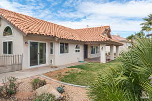 Rear view of property illustrating sliding glass door from family/den as well as covered patio